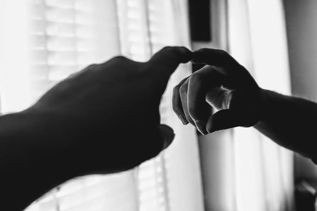foto em preto e branco com dedo indicador tocando o espelho e sendo refletido